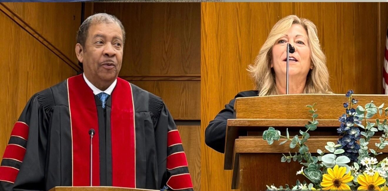 man on the left in a robe and a woman on the right standing at a podium